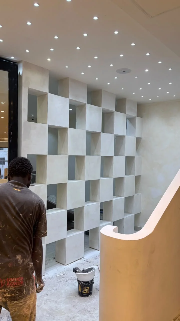 Person working beside a wall of recessed display compartments